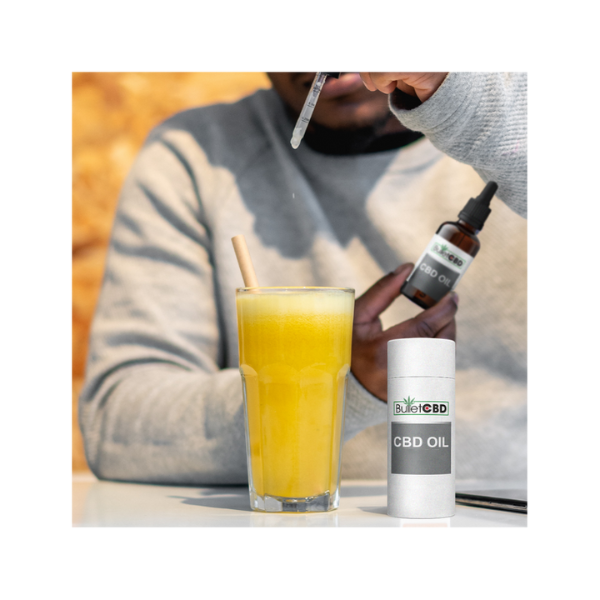 Bullet CBD Oil drops into orange juice glass