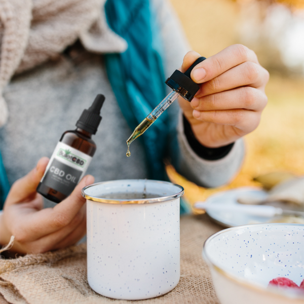 Bullet CBD oil drops in cup of tea