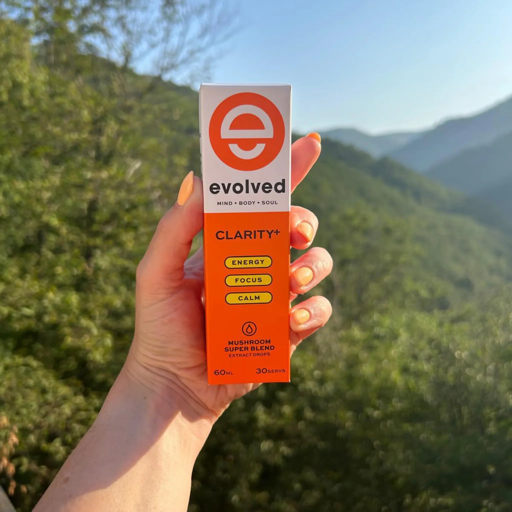 Evolved Daily Clarity+ Mushroom Extract with nature background